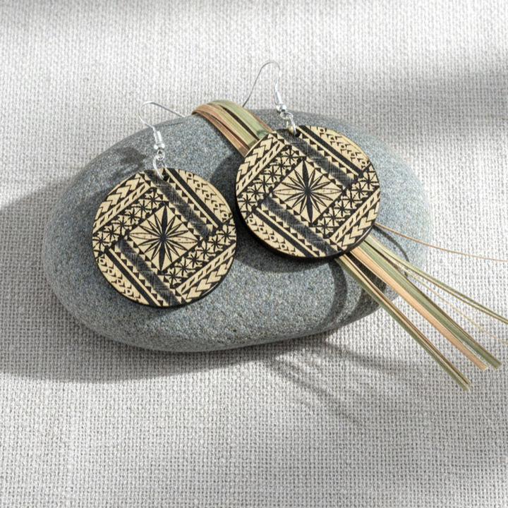 Samoan Round earrings styled on linen stone; brushed gold metallic acrylic pair.