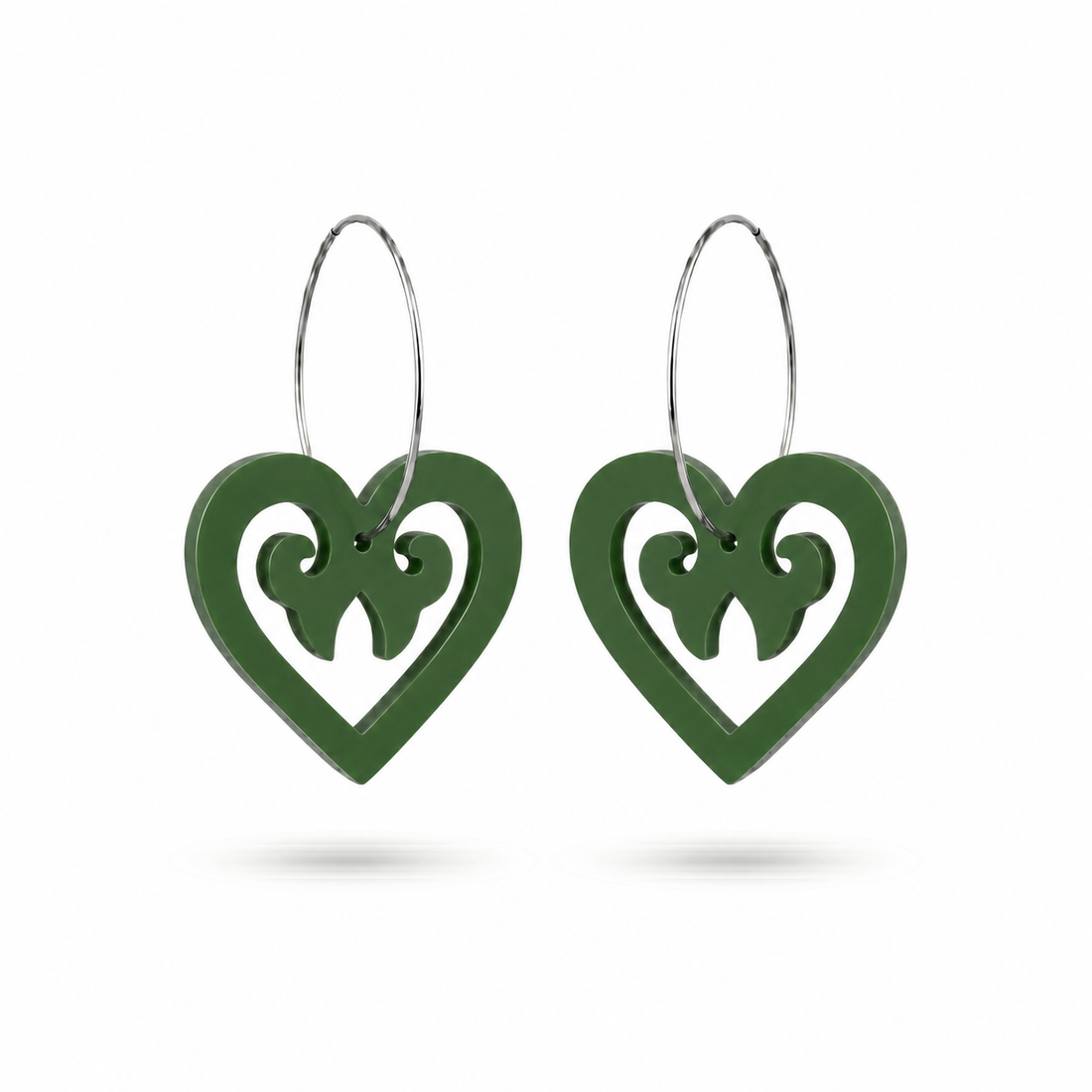 Pair of Aroha Heart Open earrings in fern-green Pounamu Satin Acrylic, with open-heart koru cutouts and large silver-coloured hoops.