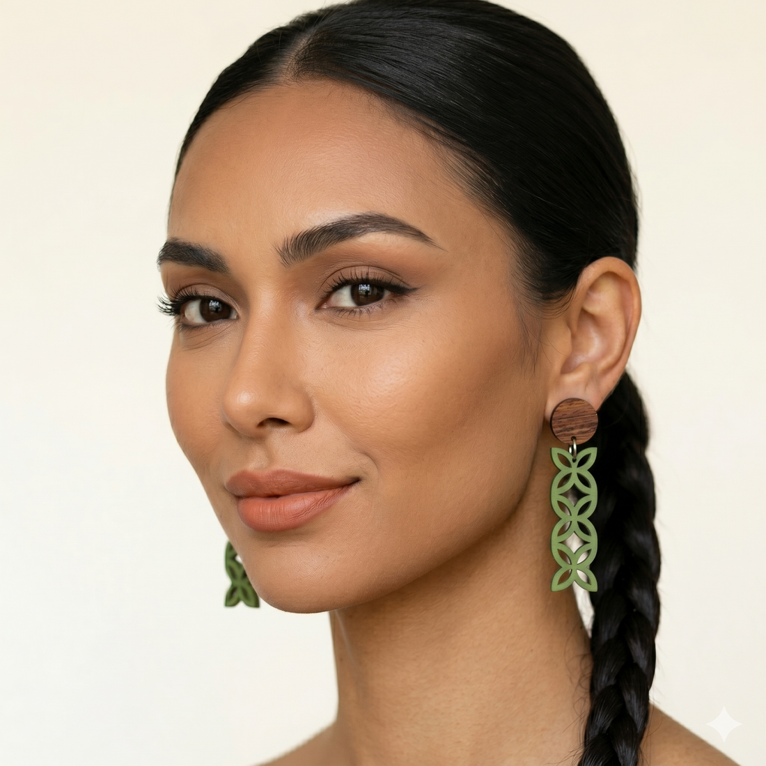 Frangipani Triple Wood Studs worn by model; natural wood studs above pounamu satin columns of three flowers.