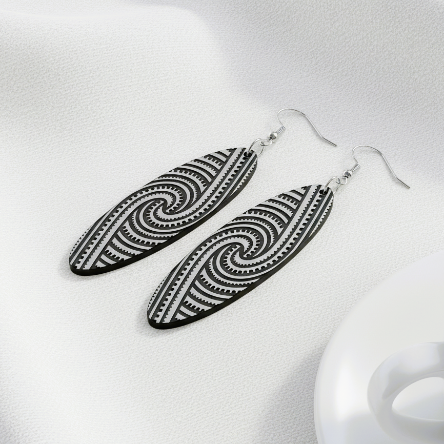 Kapa Rua earrings, silver brushed metallic laying on white linen with a coffee cup.