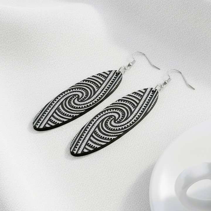 Kapa Rua earrings, silver brushed metallic laying on white linen with a coffee cup.