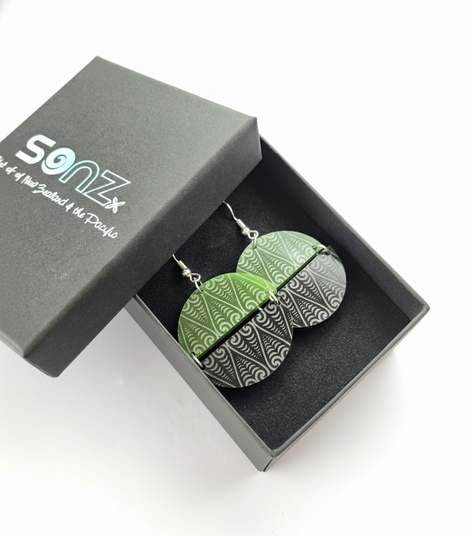 Kōwhaiwhai Symmetry earrings in SoNZ gift box; pounamu-tone top with engraved black base.