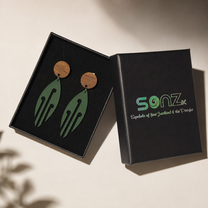 Ponga Wood Stud earrings in Pounamu Satin Acrylic presented in an open SONZ gift box in a professional studio setting.