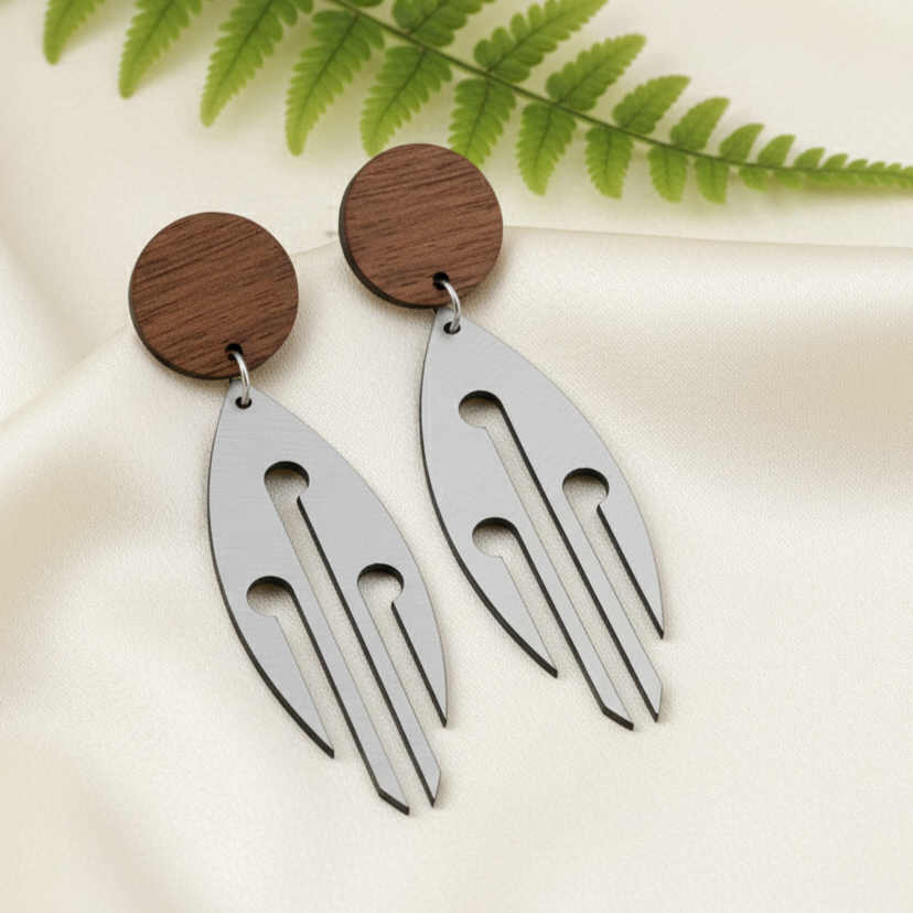 Ponga Wood Stud earrings on silk with fern; brushed silver metallic drops with natural wood studs.