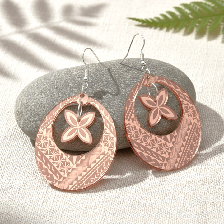 Samoan Hoop Frangi earrings on soft fabric with leaf shadow; rose-gold mirror pair and gold mirror pair.